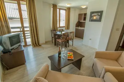 a living room with a couch and a tv and a table at Banderitsa Apartment 2 in Bansko