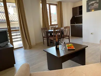a living room with a table with a bowl of fruit on it at Banderitsa Apartment 2 in Bansko