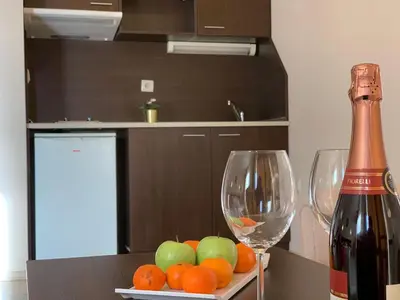 a table with two wine glasses and a bowl of fruit at Banderitsa Apartment 3 in Bansko