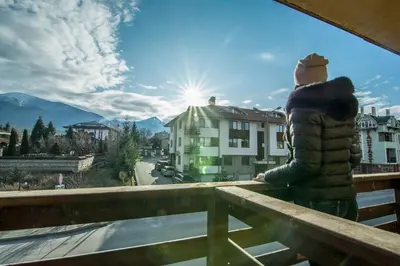 a person standing on a balcony looking at the mountains at Banderitsa Apartment 3 in Bansko