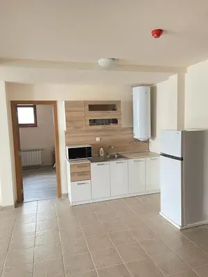 a kitchen with white cabinets and a white refrigerator at Bron's Suite in Pamporovo