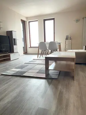 a living room with a couch and a table and chairs at Bron's Suite in Pamporovo