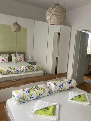 a room with two beds and a mirror at Апартаменти Viviana in Plovdiv