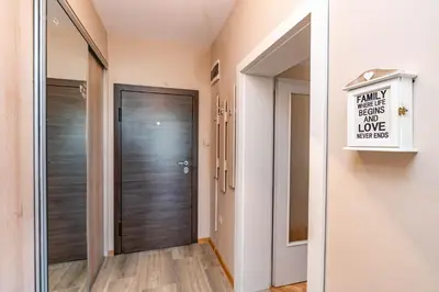 a hallway with a wooden door and a sign at Апартаменти Viviana in Plovdiv
