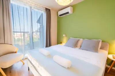 a bedroom with a large white bed with a window at Design 1BDR Apartment near City Center in Sofia