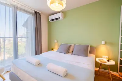 a bedroom with a large white bed with a window at Design 1BDR Apartment near City Center in Sofia