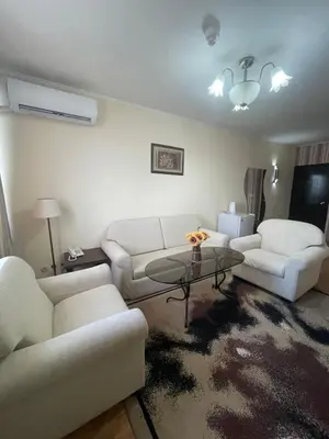 a living room with two white couches and a table at Хотел Ботевград in Botevgrad