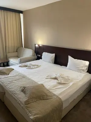 a large bed in a hotel room with towels on it at Хотел Ботевград in Botevgrad
