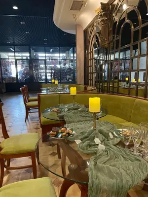 a restaurant with couches and tables with plates of food at Хотел Ботевград in Botevgrad