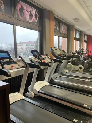 a gym with several tread machines in a room at Хотел Ботевград in Botevgrad
