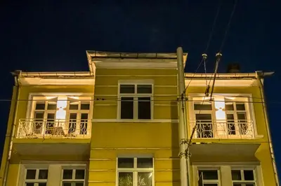 a yellow building with windows and balconies at night at South 22 - Brand New Modern 1BD Apt in Sofia Center by Flat Mаnager in Sofia