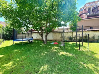 a yard with a tree and a swing set at Stracciatella Homes Apartment in Sofia