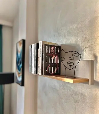 a book shelf with books and a shelf with a shelf captain pound at Stracciatella Homes Apartment in Sofia