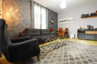 a living room with a couch and a table and chairs at INB Iconic Spot in Sofia