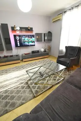 a living room with a glass table and a tv at INB Iconic Spot in Sofia