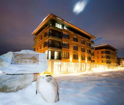 a building in the snow in front of a building at Sunrise View with Free SPA and Bottle of Wine in Cornelia Deluxe Residence, free Parking in Bansko