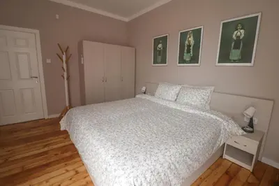 a bedroom with a white bed and two pictures on the wall at New 1930s quiet central apartment w/AC - 2 bedroom in Sofia