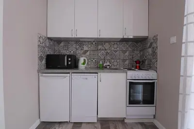 a white kitchen with white cabinets and a microwave at New 1930s quiet central apartment w/AC - 2 bedroom in Sofia