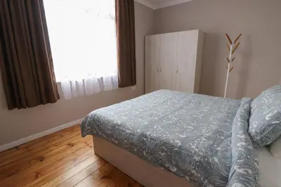 a bedroom with a bed with a blue comforter and a window at New 1930s quiet central apartment w/AC - 2 bedroom in Sofia