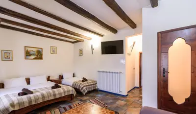 a living room with two beds and a tv at Chalet Garibaldi - Total Chalets in Bansko