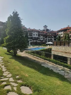 a park with a fence and a tree and buildings at IG Apartments Royal Towers 426 in Bansko