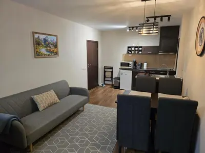 a living room with a couch and a kitchen at IG Apartments Royal Towers 426 in Bansko