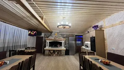 a dining room with a fireplace and tables and chairs at Къща за гости Михаела in Chepelare