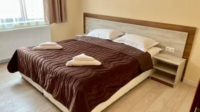 a bedroom with a bed with two towels on it at Къща за гости Михаела in Chepelare
