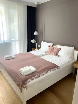 a large white bed with two folded towels on it at S íRMA Apartment - The Diamond of Sofia in Sofia
