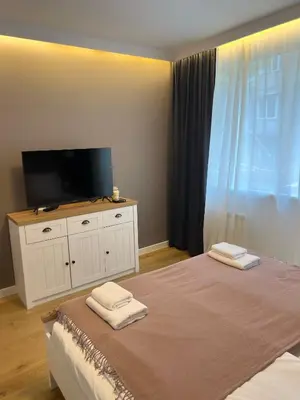 a bedroom with a tv and a bed with two towels at S íRMA Apartment - The Diamond of Sofia in Sofia