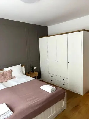 a bedroom with a bed and a large white cabinet at S íRMA Apartment - The Diamond of Sofia in Sofia