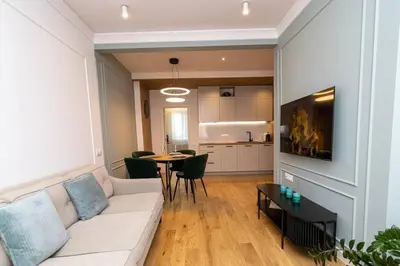 a living room with a white couch and a table at S íRMA Apartment - The Diamond of Sofia in Sofia