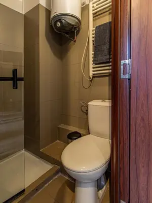 a small bathroom with a toilet and a shower at Eagle's Nest - Sofia Central Studio in Sofia