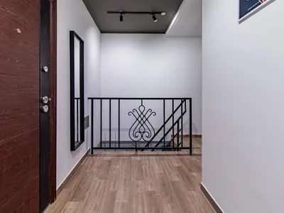 a hallway with a black iron railing and white walls at Lion's Bridge Haven - Sofia Central Studio in Sofia