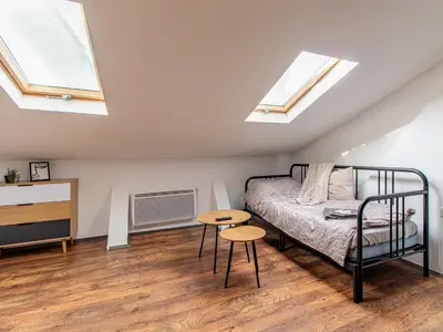 a bedroom with skylights and a bed and a table at Lion's Bridge Haven - Sofia Central Studio in Sofia