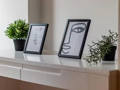 two framed pictures sitting on a counter with plants at Lion's Bridge Haven - Sofia Central Studio in Sofia