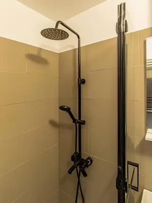 a shower with a shower head in a bathroom at Vazov Loft - Central Sofia Studio in Sofia