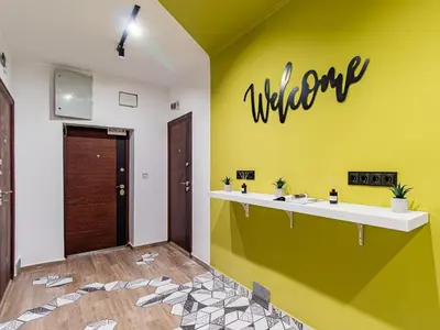 a bathroom with a yellow wall with the welcome sign on it at Serdika Loft - Central Sofia Studio in Sofia