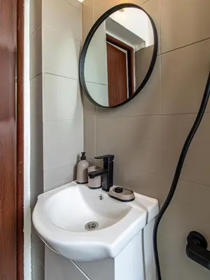 a bathroom with a white sink and a mirror at Largo Loft - Central Sofia Studio in Sofia