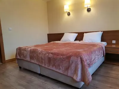 a bedroom with a large bed with two pillows at Къща за гости ГРАНИТ in Bansko