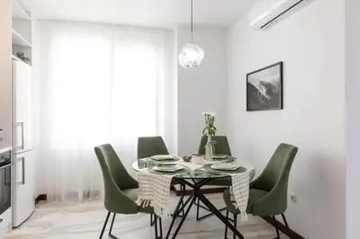 a dining room with a table and green chairs at Didi's Central Designer Apartments in Sofia
