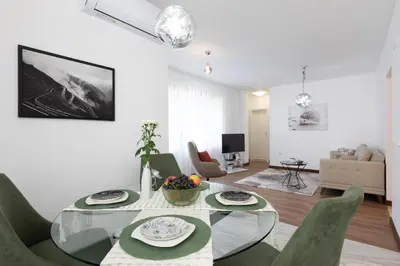 a living room with a glass table and green chairs at Didi's Central Designer Apartments in Sofia