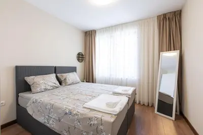 a small bedroom with a bed and a mirror at Didi's Central Designer Apartments in Sofia