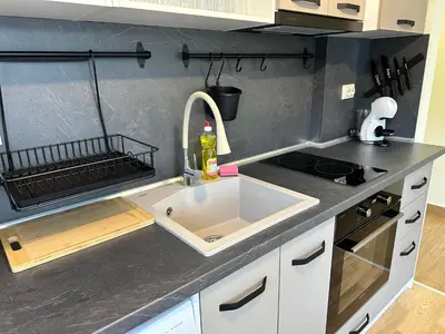 a kitchen counter with a sink and a stove at Pine Tree - charming apartment in Bansko