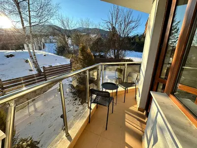a balcony with chairs and a view of the snow at Pine Tree - charming apartment in Bansko