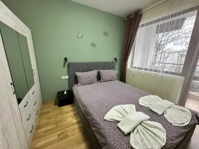 a bedroom with a bed with two towels on it at Pine Tree - charming apartment in Bansko