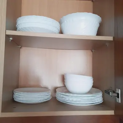 a shelf with plates and bowls in a cabinet at lux Apartament L201 in Bansko