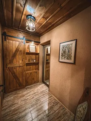 a room with a wooden door and a room with a chair at Кътче in Leshten
