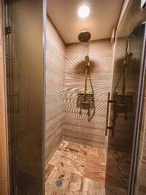 a shower with a glass door in a bathroom at Кътче in Leshten