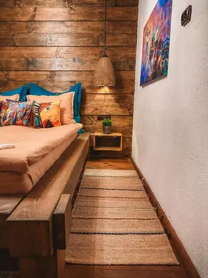a room with a bed with a wooden wall at Кътче in Leshten